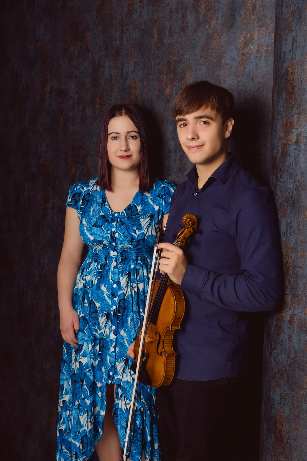 Pauline und Lewin Creuz mit Violine vor blauem Hintergrund